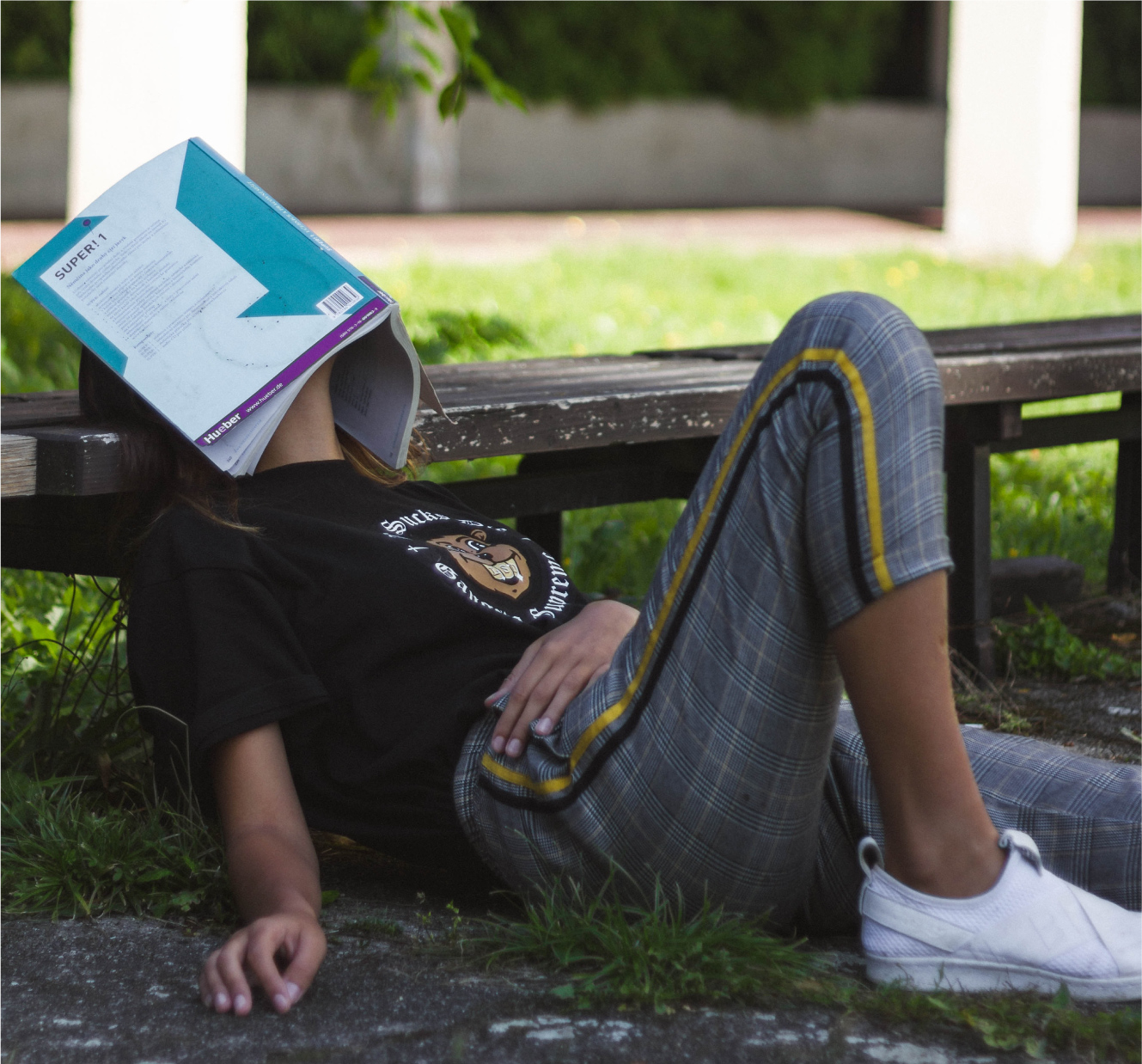 Student bored with book over the face (procrastinating)