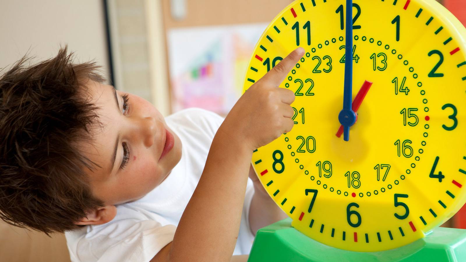 Kid pointing at a clock